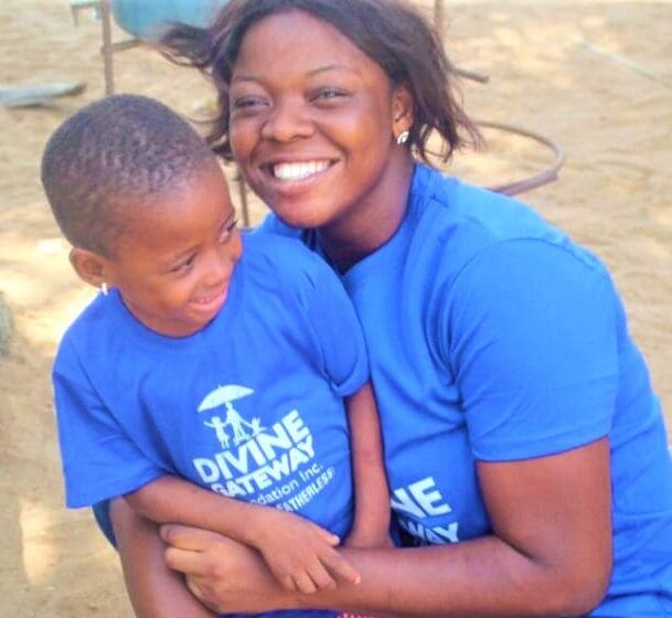 A woman and child in blue shirts smiling for the camera.