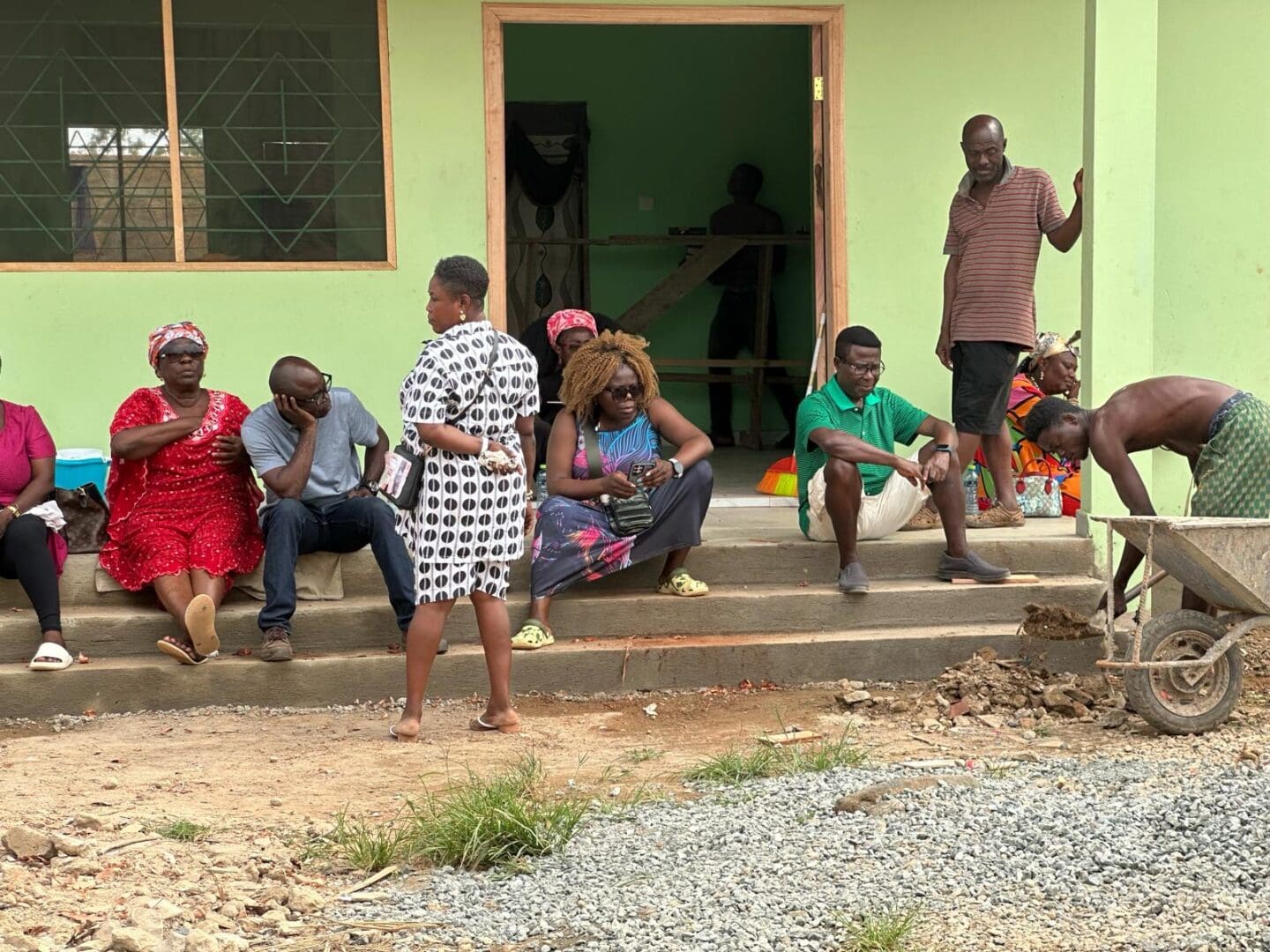 A group of people sitting on steps outside a house.