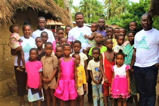 A group of people standing in front of some trees