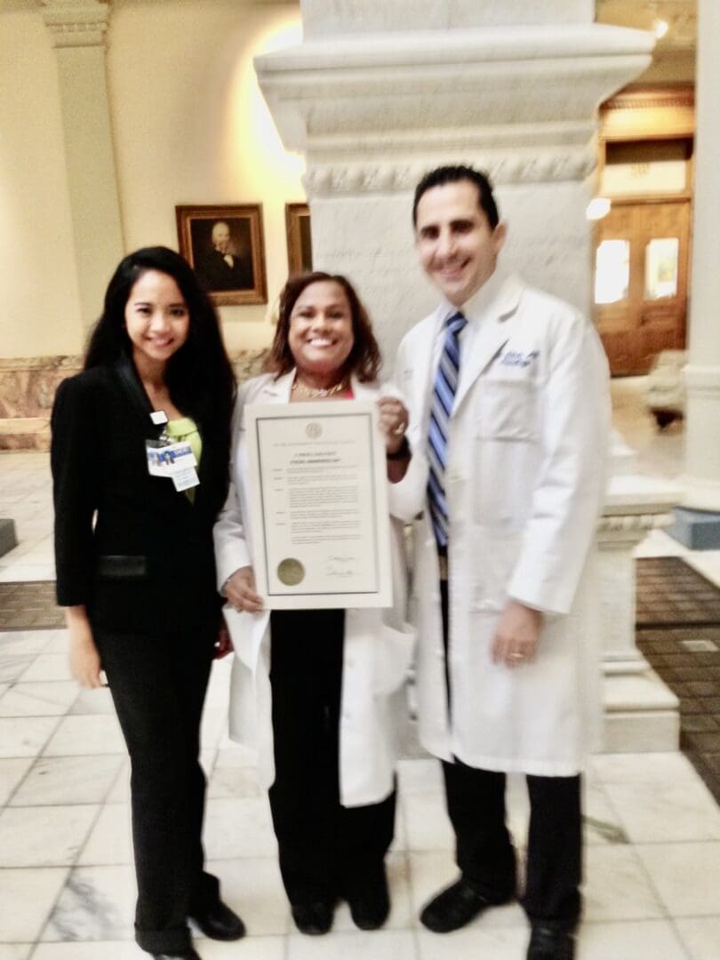 A woman holding an official document with two men.