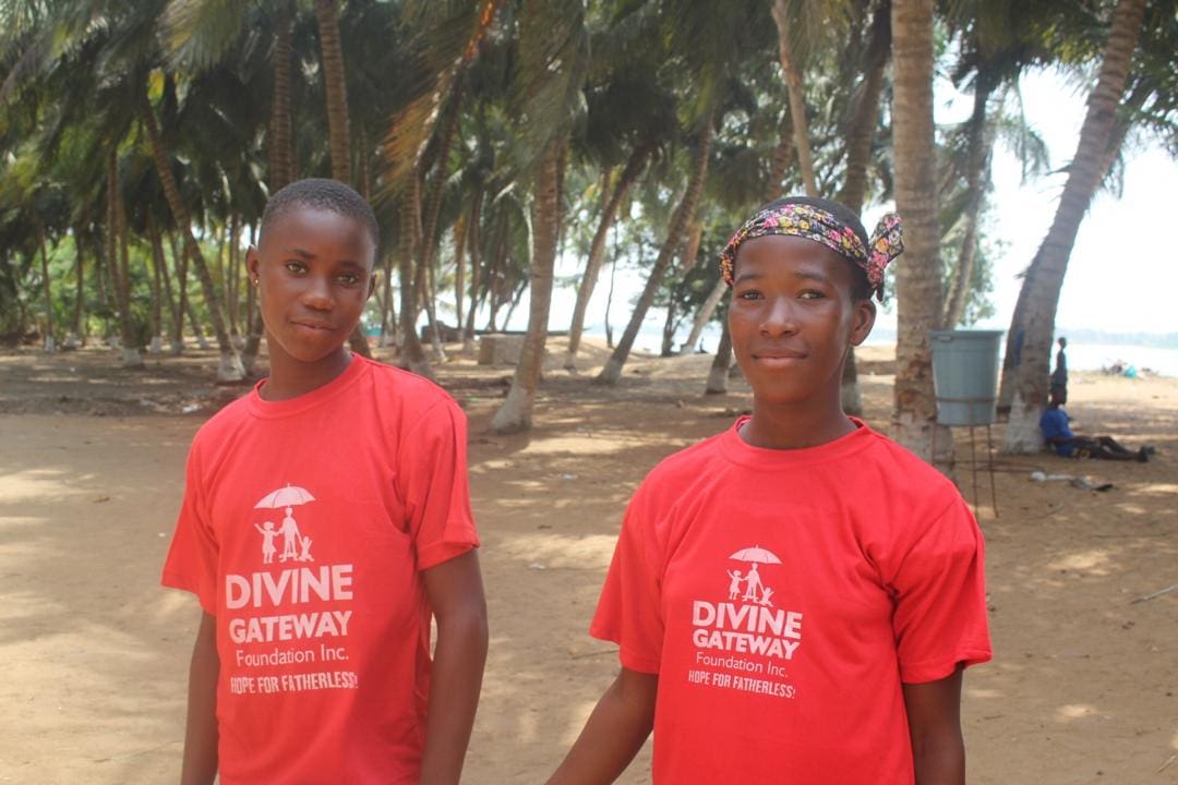 Two young men standing in front of a beach.