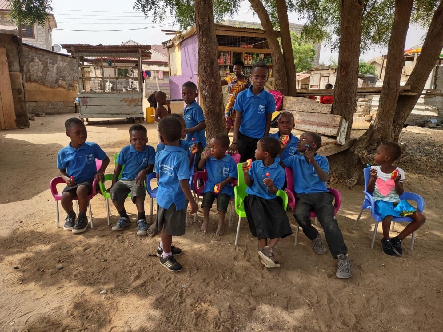 A group of children sitting in the dirt.