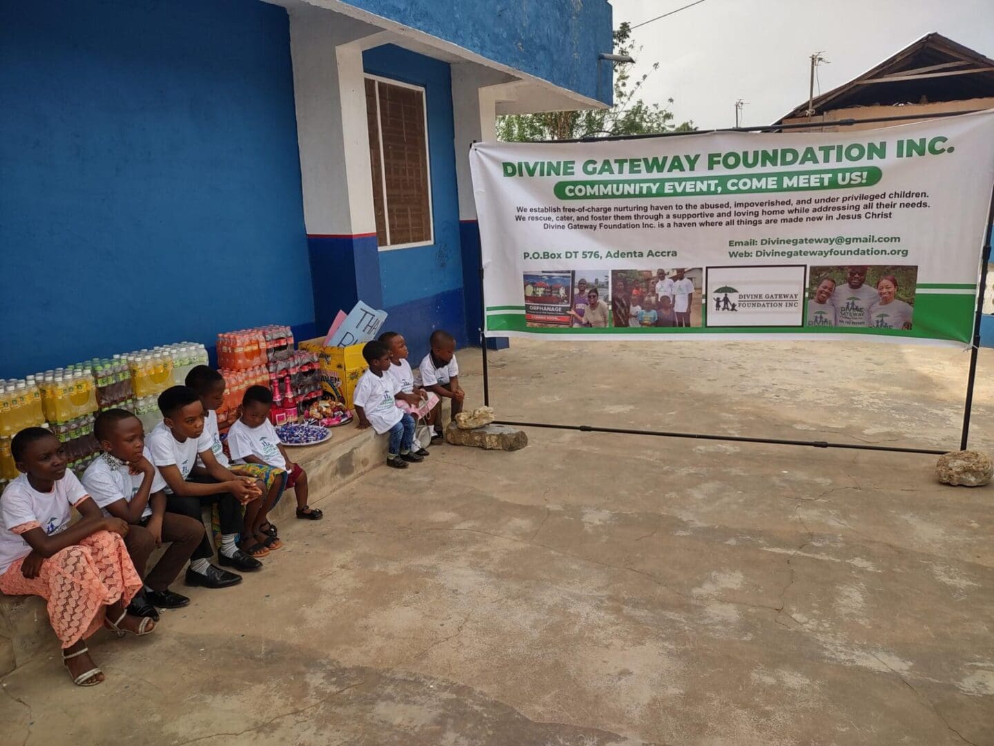 A group of children sitting on the ground outside.