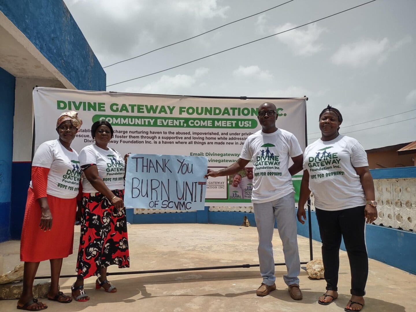 A group of people standing in front of a sign.