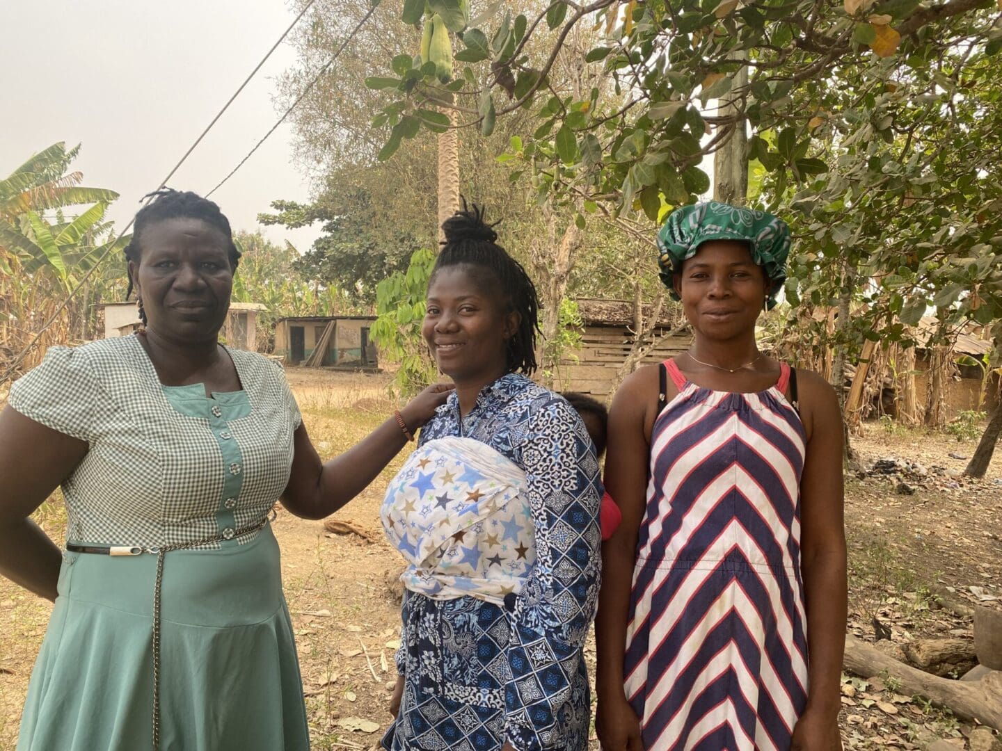 Three women standing next to each other in a field.