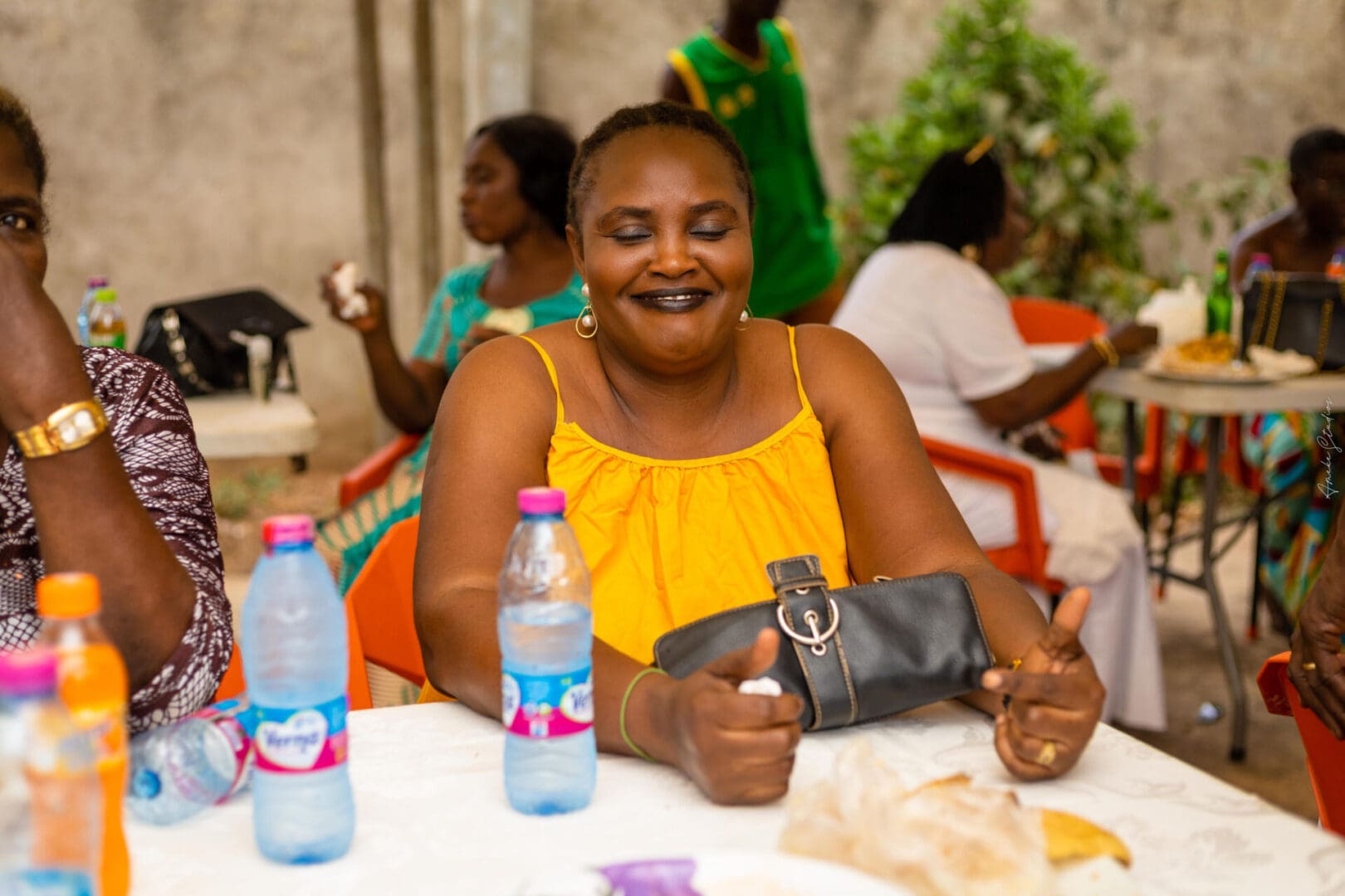 A woman sitting at a table with water bottles.