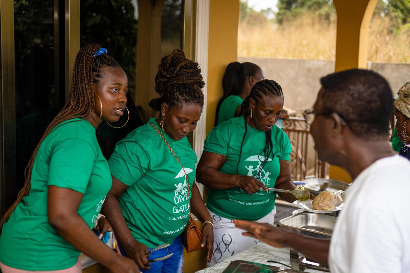 A group of women in green shirts standing around.