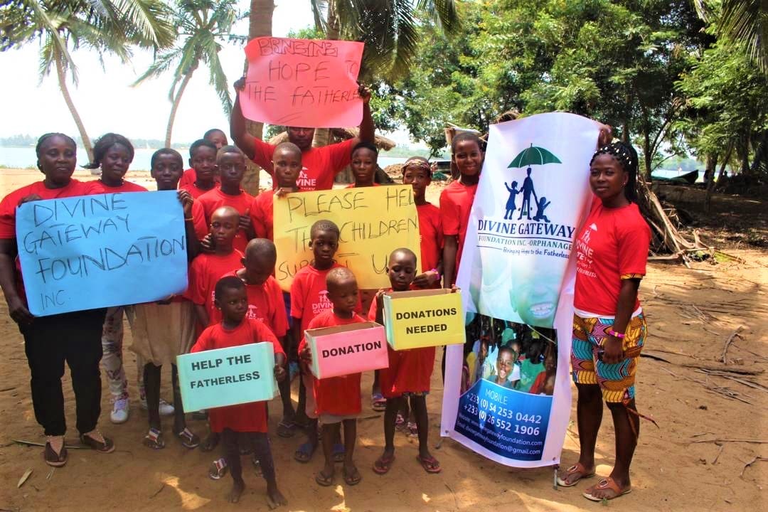 A group of people holding signs and standing in front of trees.