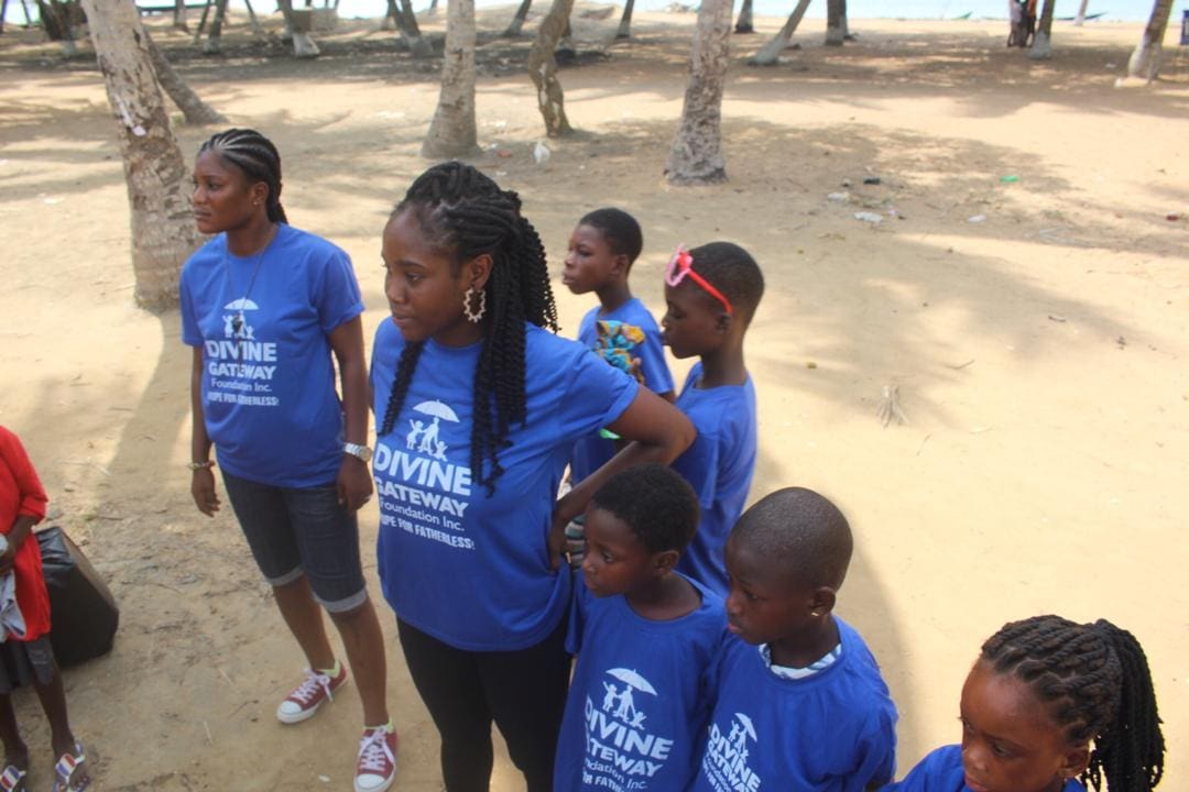 A group of children standing in the sand.