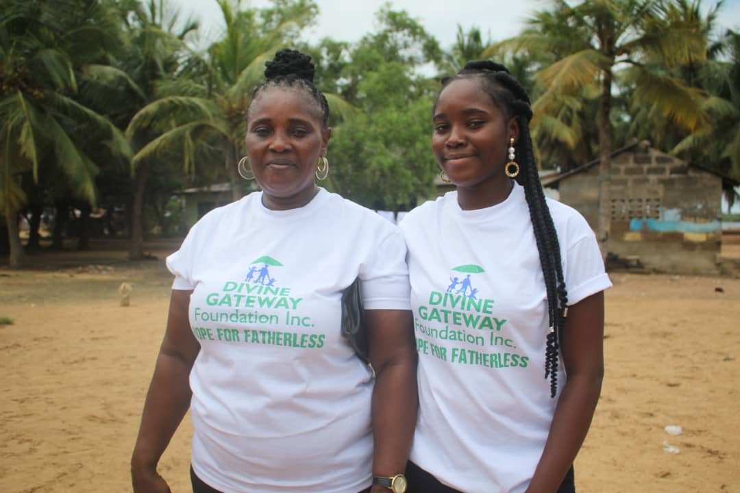 Two women standing next to each other wearing white shirts.