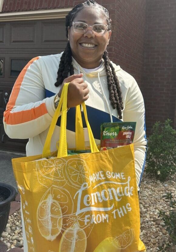 A woman holding a bag of food in her hands.