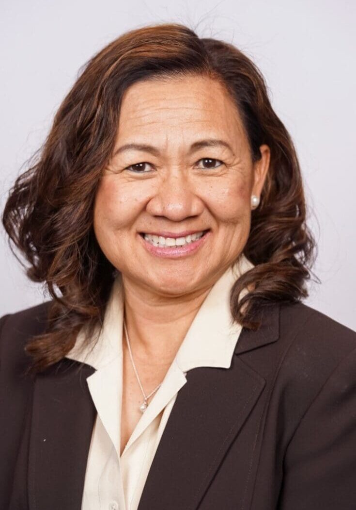 A woman in a suit smiling for the camera.